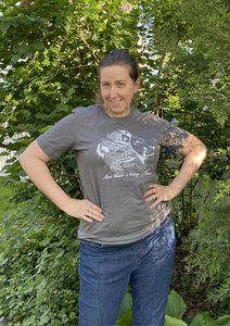 girl wearing a grey Charcoal "Lion" T-Shirt in front of trees