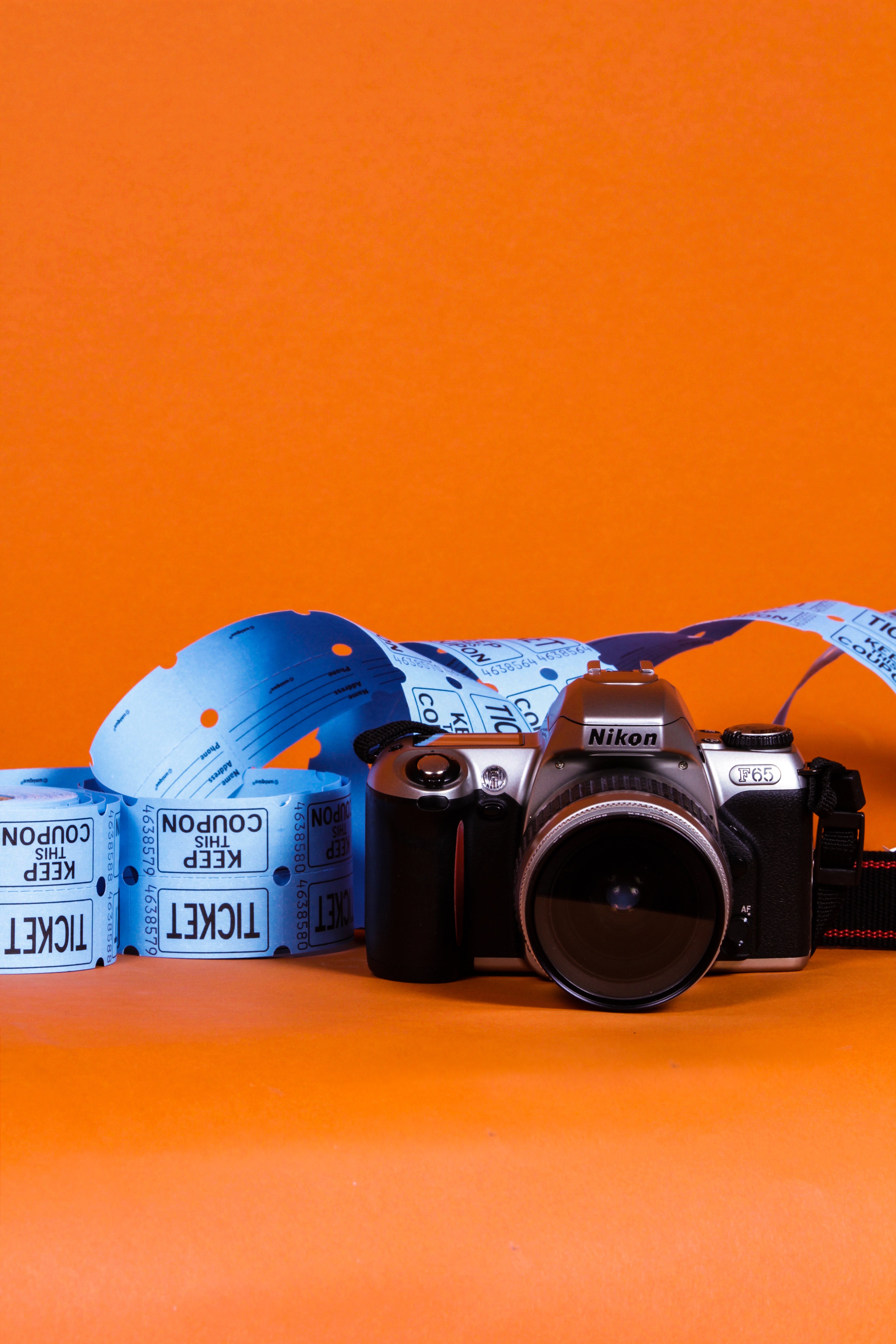 camera and blue tickets displayed in front of orange background