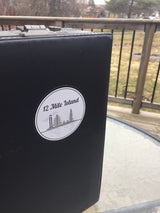 12 Mile Island' sticker with lamp post and tree graphics on laptop